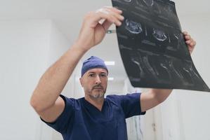 Orthopedist doctor examining X-ray picture in hospital or clinic photo