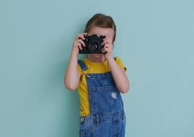 Cute little girl taking picture using  film photo camera