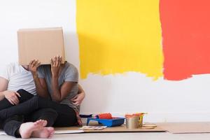 young multiethnic couple playing with cardboard boxes photo