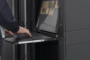 Close up on Data Center Engineer hands Using keyboard on a supercomputer Server Room Specialist Facility with Male System Administrator Working with Data Protection Network for Cyber Security. photo