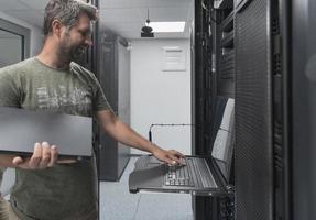Close up on Data Center Engineer hands Using keyboard on a supercomputer Server Room Specialist Facility with Male System Administrator Working with Data Protection Network for Cyber Security. photo