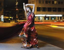 mujer elegante en la calle de la ciudad por la noche foto
