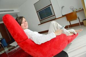 young woman watching tv at home photo