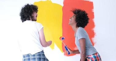 multiethnic couple painting interior wall photo