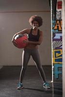 black woman carrying crossfit ball photo