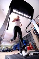 Girl running on the treadmill in the gym photo