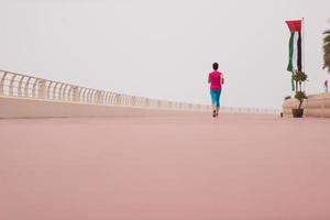 woman busy running on the promenade photo