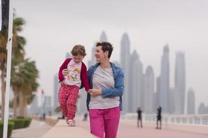 madre y niña linda en el paseo marítimo foto