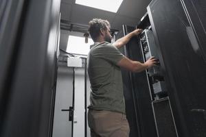 IT engineer working In the server room or data center The technician puts in a rack a new server of corporate business mainframe supercomputer or cryptocurrency mining farm. photo