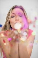 woman blowing confetti in the air photo