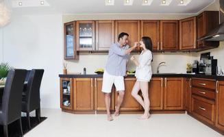 feliz pareja joven divertirse en la cocina moderna foto