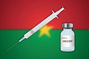 Syringe and vaccine vial on blur background with Burkina Faso fl vector