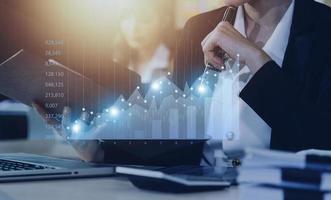 Businessman with a tablet in his hand And touching on the screen That shows a business graph. The concept of starting a new business that goes better. photo