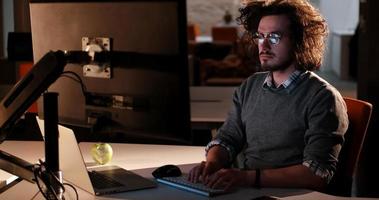 man working on computer in dark office photo