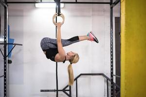 mujer trabajando en anillos de gimnasia foto