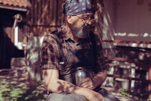 Spoon master in his workshop with wooden products and tools photo