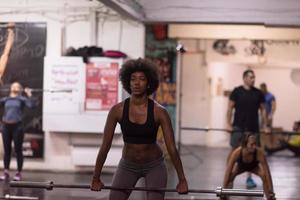 black woman lifting empty bar photo