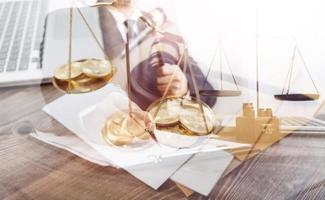 Justice and law concept.Male judge in a courtroom with the gavel, working with, computer and docking keyboard, eyeglasses, on table in morning light photo