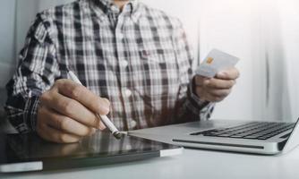 technology, people and online shopping concept - happy smiling man with tablet pc computer and credit card at home photo