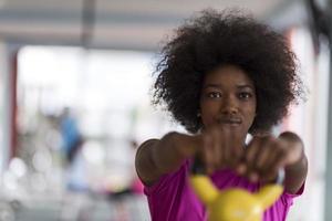 woman working out in a crossfit gym with dumbbells photo