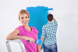 happy couple paint wall at new home photo