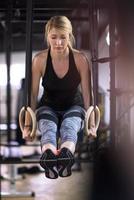 woman working out pull ups with gymnastic rings photo