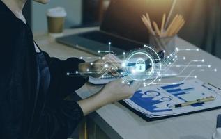 Cybersecurity and privacy concepts to protect data. Lock icon and internet network security technology. Businessman protecting personal data on smart phone with virtual screen interfaces. photo