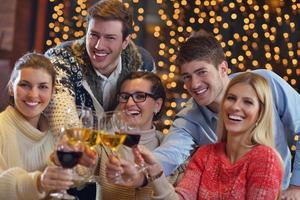 Group of happy young people drink wine at party photo