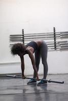 black woman lifting empty bar photo