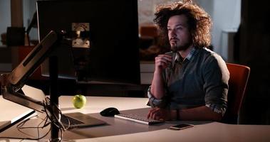 man working on computer in dark office photo