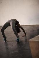 black woman standing in bridge pose photo