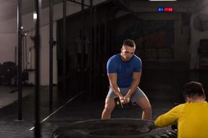 man workout with hammer and tractor tire photo