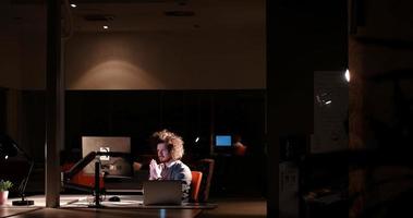 hombre trabajando en una computadora en una oficina oscura foto