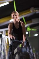 athlete woman doing battle ropes cross fitness exercise photo