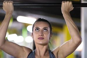 mujer haciendo pull ups en la barra horizontal foto