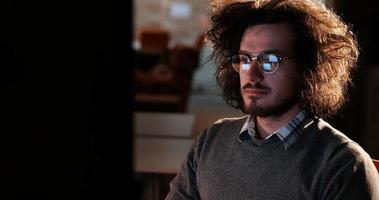 man working on computer in dark office photo