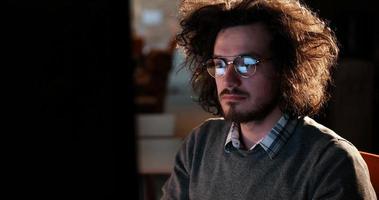 man working on computer in dark office photo