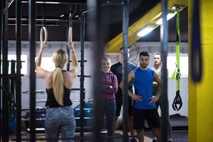 mujer trabajando con entrenador personal en anillos de gimnasia foto