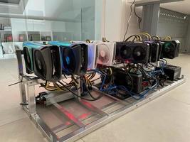 Row of bitcoin miners set up on the wired shelfs. Device for mining crypto currency. Mining cryptocurrency. Bitcoin farm. Machines for mining cryptocurrency bitcoin. Electronic device at day. photo