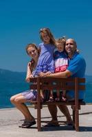 portrait of young happy family with daughters by the sea photo