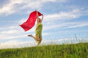 beautiful woman with red scarf on meadow photo