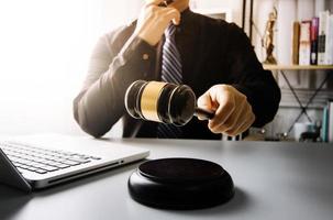 Business and lawyers discussing contract papers with brass scale on desk in office. Law, legal services, advice, justice and law concept picture with film grain effect photo