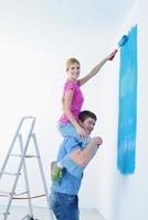 happy couple paint wall at new home photo