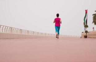 woman busy running on the promenade photo