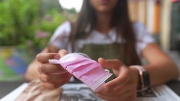 femme portant un masque au restaurant, parle au téléphone video