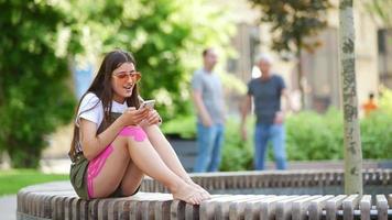 Woman sitting outside using phone video