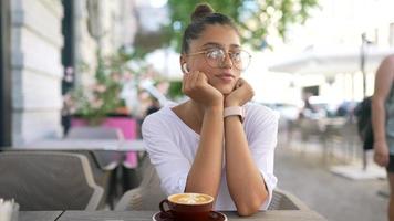 Beautiful woman sitting at outside table cafe video