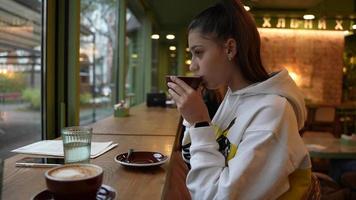 mujer bebe café en el asiento junto a la ventana video