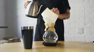 Brewing coffee in a glass coffee maker using the pour over method video