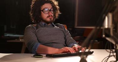 hombre trabajando en una computadora en una oficina oscura foto